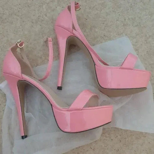 Pair of pink high-heeled shoes on a textured surface