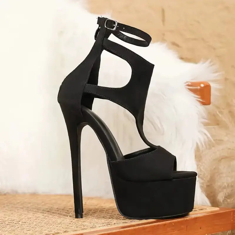 Black high-heeled sandal on a wooden surface with a soft white and brown background